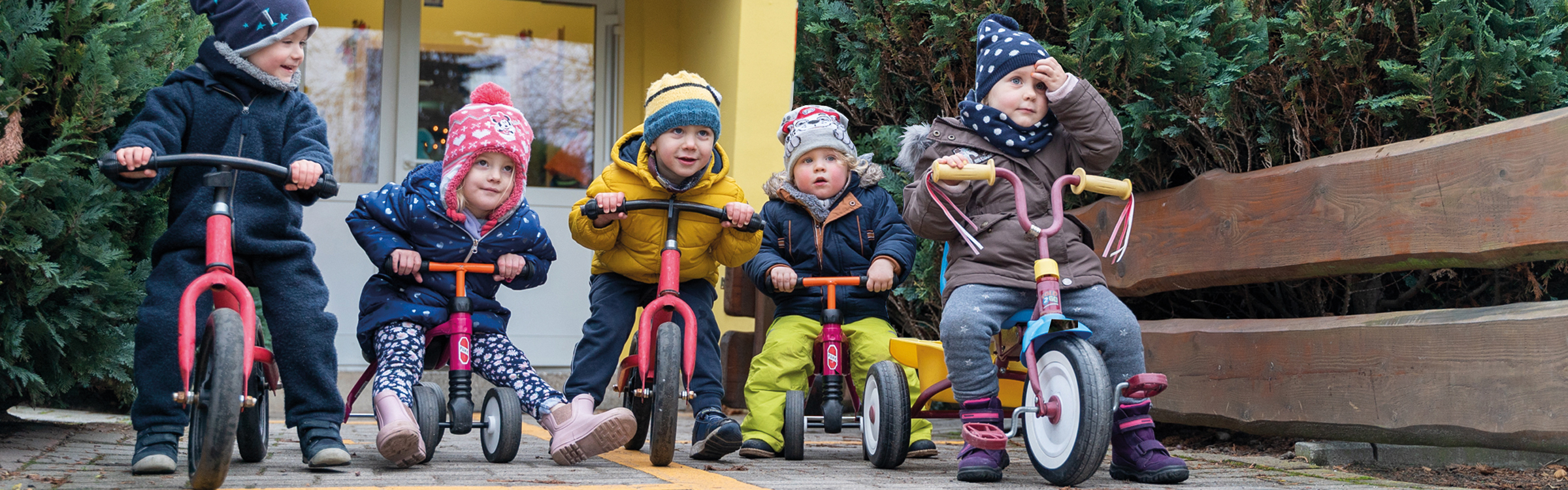 Gruppe von Kinder erkundet den Spielplatz auf Rollern