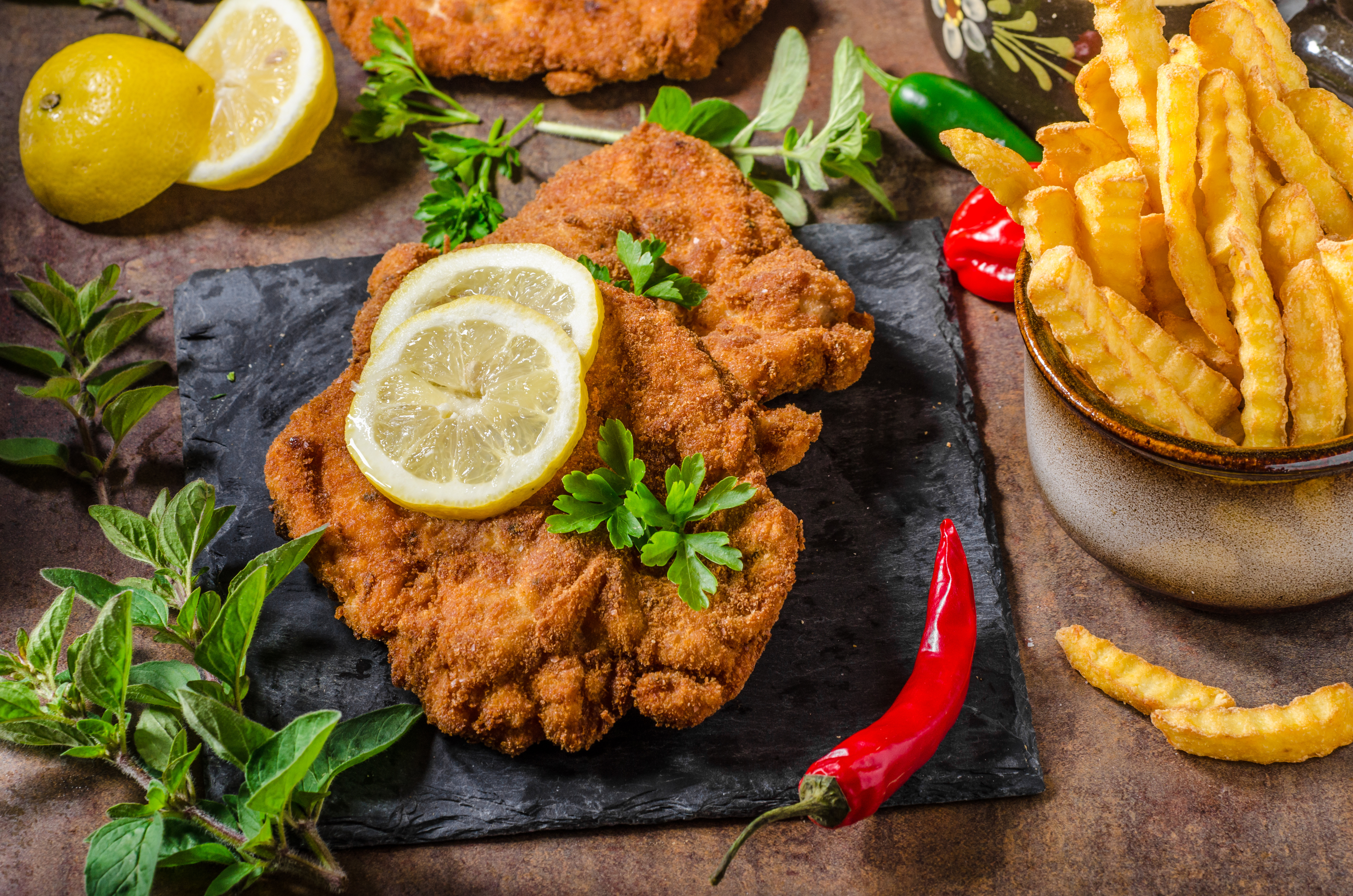 Schnitzel with fries, salad and herbs