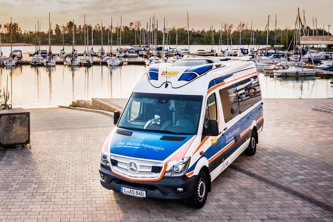 Wünschewagen vom ASB Sachsen Wünschewagen vom ASB Sachsen in einem kleinen Hafen mit Booten im Hintergrund