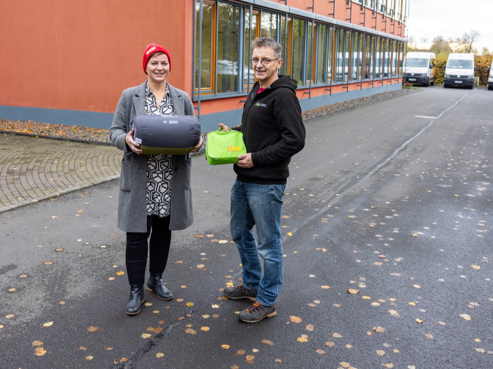ASB-Kältehilfe-Aktion 2023: Geschäftsführerin Anna Naumann übergibt Schlafsäcke und Hygienesets an Tino Neufert vom Projekt HILFEBUS/Safe - Straßensozialarbeit für Erwachsene